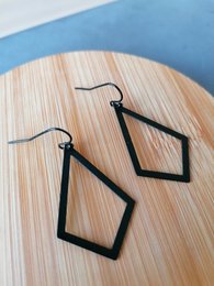 Black rhombus-shaped statement earrings with a modern, geometric design.
