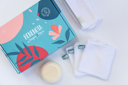 Facial care set includes gray and off-white facial cleansers, soft towels, and a decorative box.