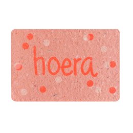 Colorful confetti-patterned card with the text "hoera" (Dutch for "hurray") printed in a bold font. The card has a textured, paper-like appearance with scattered dots and splatters in shades of orange.