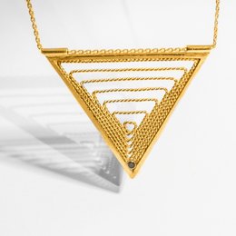 Triangular gold-plated pendant with layered geometric design and textured surface.