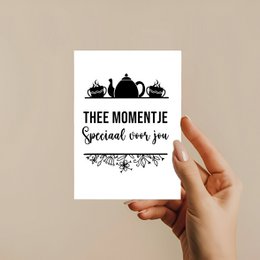 A greeting card with a black and white silhouette of tea cups and a teapot, along with the text "THEE MOMENTJE" and "Warm Bevelled".
