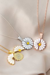 Delicate gold-toned daisy necklace with engraving option, featuring a pendant with white and yellow enamel petals.