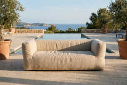 Beige outdoor sofa, two-seater, fabric upholstery, modern minimalist design, weather-resistant garden furniture