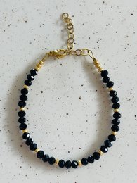 A black and gold beaded bracelet with a faceted design.