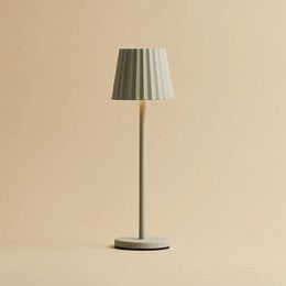 A tall, grey ribbed table lamp made of iron with dimmable lighting and 3 light modes, rechargeable via wireless charging station.