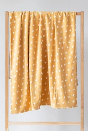 A yellow and white patterned jacquard beach towel with a polka dot design.