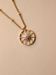 Gold-toned necklace with a circular pendant featuring a star-like design.