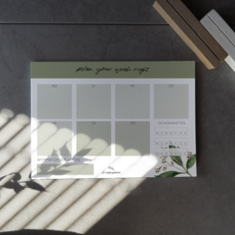 A notepad with a DIN A5 size, made of PEFC uncoated paper, featuring a weekly planner layout and a floral design.