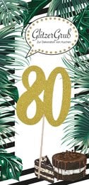 A gold glitter number 80 cake topper on a tropical leaf background, with the text "Green Grass Designs" and "80" in gold glitter.