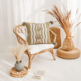 Decorative square pillow cover with intricate woven patterns and tasseled edges, made of natural materials in neutral tones.