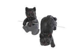 A black polystone hanging sculpture of two cats.