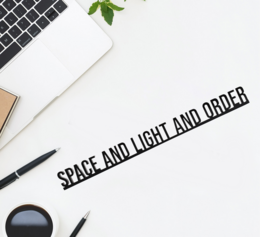 Decorative architectural quote statue with text "Space and Light and Order" in black lettering on a light-colored wooden surface.