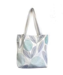 Aqua tote bag with zip pocket, made of a light, patterned fabric with leaf-like designs in shades of blue and gray.