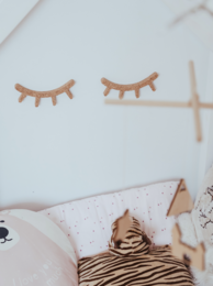 Decorative wall stickers featuring whimsical eyelash designs in neutral tones, suitable for a child's bedroom or nursery.