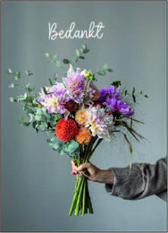 A vibrant bouquet of colorful flowers, including pink, purple, and orange blooms, held in a person's hand against a gray background with the word "Bedankt" written above.