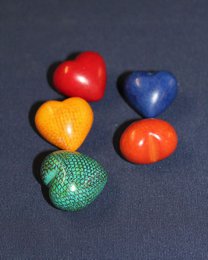 Colorful heart-shaped soapstone statues in various vibrant hues including red, blue, yellow, and green.