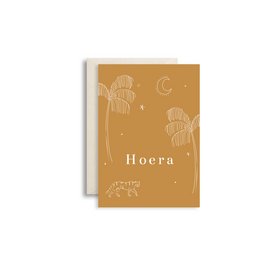 Ocher-colored greeting card with the text "Hoera" and whimsical illustrations of palm trees and crescent moons.