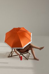 A large, colorful umbrella in a variety of vibrant shades including yellow, red, orange, light pink, cool grey, and black. The umbrella has a sleek, modern design and is packaged in a tube for easy storage and transport.
