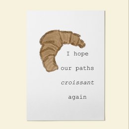 A friendship card with a croissant image and the text "I hope our paths croissant again". The card has a simple, minimalist design with a beige background.