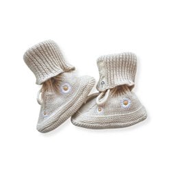 Cream knit booties with daisy pattern, ribbed cuff, drawstring closure, soft baby footwear.