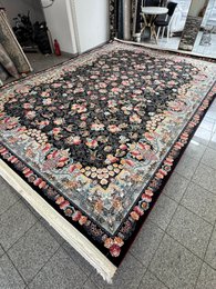 Large dark blue area rug with intricate floral and geometric patterns, suitable for living rooms or bedrooms.