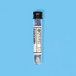 Shimmering blue and silver glitter particles in a round container. Suitable for use in cosmetics, crafts, or decorative purposes.