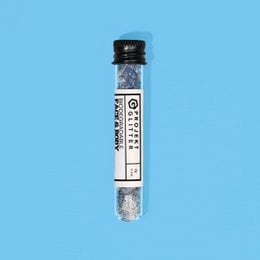 Shimmering blue and silver glitter particles in a round container. Suitable for use in cosmetics, crafts, or decorative purposes.