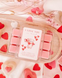  "Heart-shaped wax melts in a pink and red color palette, with a 'I Love You So Much' label. The product appears to be a romantic, Valentine's Day-themed wax melt set."
