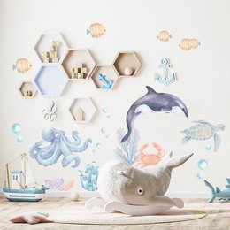 This wall sticker features a colorful underwater scene with ocean animals like a dolphin, octopus, and fish. The design includes a plush gray elephant toy and various decorative elements like hexagon shapes and bubbles. The overall style is whimsical and suitable for a kids' room.