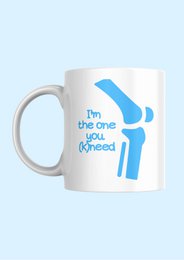  A white ceramic mug with a blue paw print design and the text "I'm the one you (k)need" printed on it. The mug appears to be a novelty or humorous item, likely intended for pet owners or animal lovers.