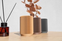 A modern geometric storage solution for desk, office, or home decor, featuring a round ripple design in earth tone colors of dark brown, graphite, and light brown. Can be used as a makeup brush holder or office desk organizer.