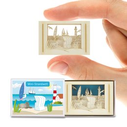 A small decorative box featuring a silhouette of a beach scene with palm trees, sailboats, and other coastal elements. The box is available in multiple language variants.