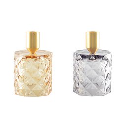 A set of 2 round, textured candlesticks in yellow and gray colors with gold-tone metal tops.