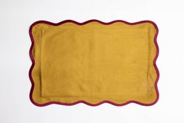 Rectangular velvet cushion in a mustard yellow color with a contrasting burgundy trim.