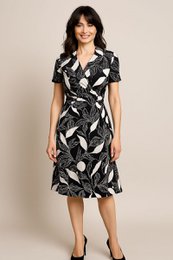 A mid-length, fluid V-neck dress with a belt, made in France. The dress features a black and white leaf print pattern. Available in sizes T38 to T52.