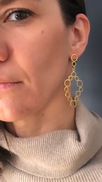 Gold-plated statement earrings with a cascading, abstract design.