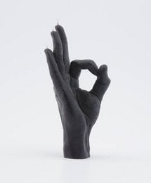 Black candle in an okay hand gesture shape. Minimalist, modern design.