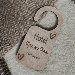 A wooden pendant with the text "Hotel Grandpa & Grandma" and heart symbols, designed as a hotel door hanger.