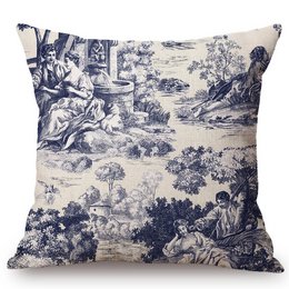 A decorative blue and white toile de jouy cushion with a pastoral scene depicting people in a countryside setting.