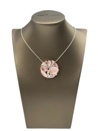 Silver-toned necklace with a pink floral pendant and matching stud earrings.