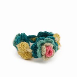 Crochet bracelet with colorful flower designs, made from 100% wool. The bracelet features a variety of vibrant floral patterns in shades of green, yellow, and pink.