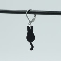 Dangling cat-shaped drop earrings in black and purple glitter finishes.