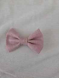  A small, pink bow hair clip for kids. The bow is approximately 7cm in size and has a soft, textured fabric.