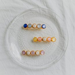 "Blackbird - Multiple colors available. Hair Clips in various colors and shapes."

The image shows a variety of colorful hair clips or barrettes in different shapes and colors. Based on the product title and category, the relevant description for this product would be:

"Blackbird hair clips available in multiple colors including blue, yellow, orange, and pink. The clips come in various shapes and styles such as round, oval, and heart-shaped."

This description covers the key details about the product - the colors, shapes, and styles of the hair clips - which would be useful for a semantic search related to hair accessories.