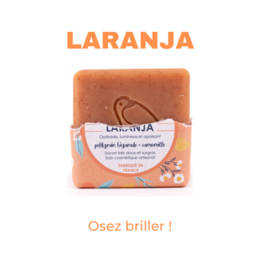 Orange-scented soap bar with floral accents.