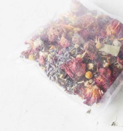 Herbal face mask with dried flowers, herbs, and spices. Includes a variety of colors, textures, and natural ingredients for a soothing and rejuvenating skincare experience.