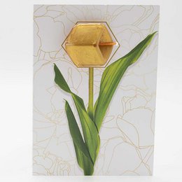 A gold-colored hexagonal greeting card with a floral design and green leaves.