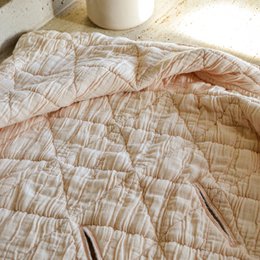  Soft, cozy, and quilted cream-colored hooded baby blanket.