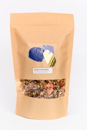 Granola mix in a brown paper bag with a blue and white label. Contains a variety of grains, nuts, and dried fruit for a sweet and crunchy snack.