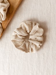 Beige gauze scrunchie with a soft, textured appearance. Made of natural, breathable fabric for comfortable wear.